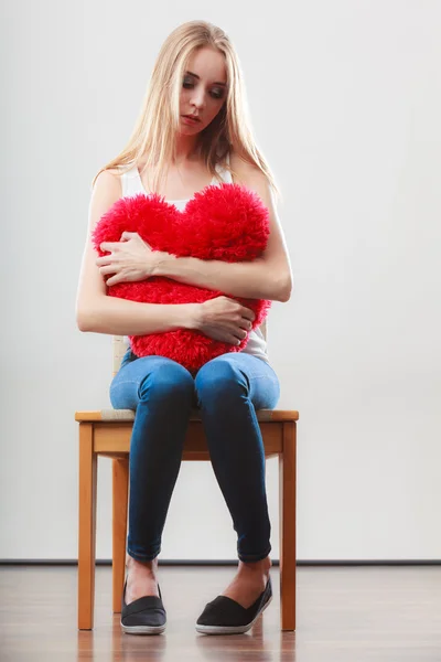 Triste mulher infeliz segurando travesseiro coração vermelho — Fotografia de Stock