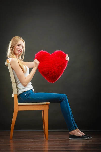 Mujer sosteniendo corazón en forma de almohada símbolo de amor — Foto de Stock