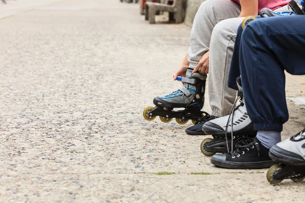 Teman-teman orang menempatkan pada sepatu roda luar ruangan . — Stok Foto