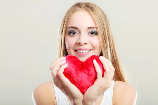 Gülümseyen kadın holding kırmızı kalp aşk sembolü — Stok fotoğraf