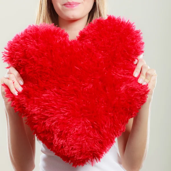 Mujer sosteniendo corazón en forma de almohada símbolo de amor — Foto de Stock