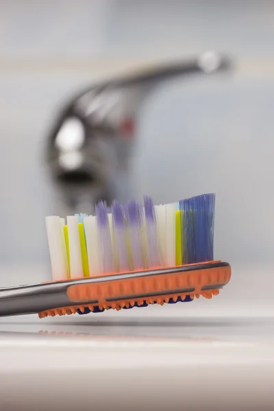 Cepillo de dientes en el baño en el fregadero — Foto de Stock