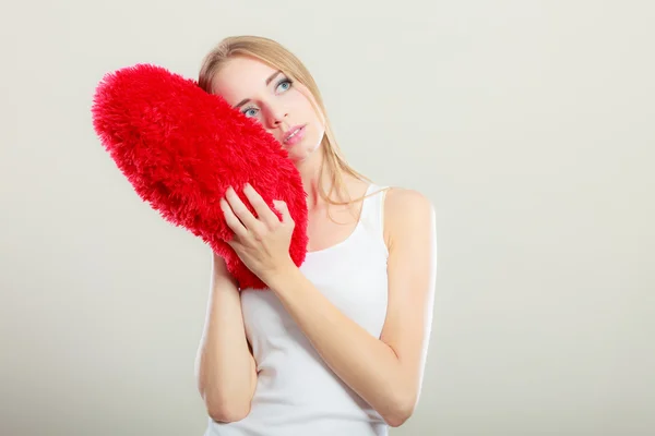 Mujer sosteniendo almohada en forma de corazón — Foto de Stock