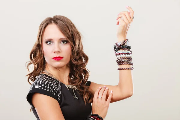 Femme avec bijoux en robe de soirée noire — Photo