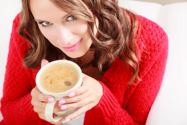 Mädchen roten Pullover hält Becher mit Kaffee — Stockfoto