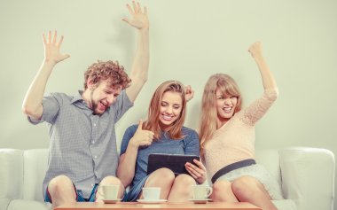 Evde tablet ile başarılı mutlu arkadaşlar.