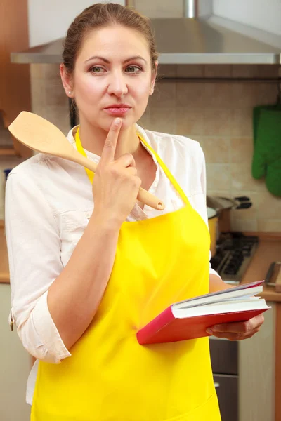 Mulher dona de casa com livro de receitas na cozinha . — Fotografia de Stock
