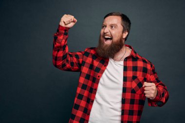 Dünya şampiyonu gibi hisseden sakallı genç bir adam, başarıyı kutluyor ya da kazanıyor, yarışmayı bitirirken evet diye bağırıyor, zafer kazanıyor ya da arzulanan bir şekilde yumruk sallıyor, teşvik ediliyor ve motive oluyor..