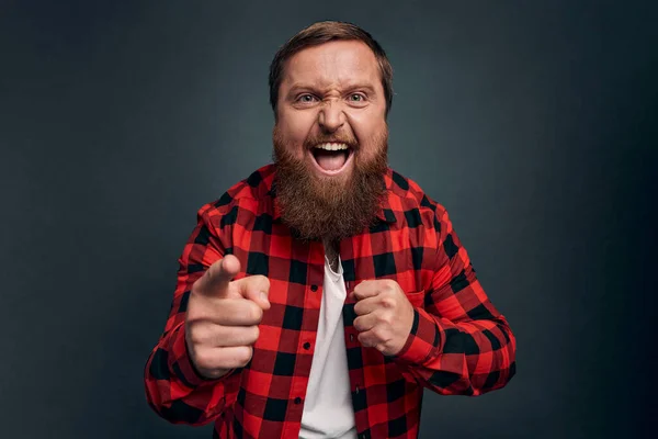 Man threatening person with angry outraged expression, lose temper standing distressed, pointing camera accuse someone, blame girlfriend, having argument and shouting, grey background.