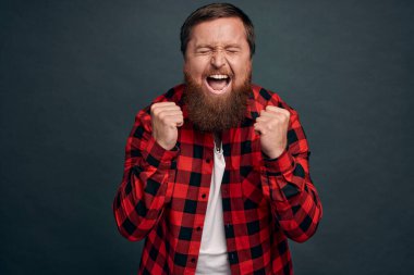 Aşırı sevinç, başarı ve yaşam hedefleri konsepti. Sevinçten havalara uçan yakışıklı adam mutluluktan çığlık atıyor, harika haberler duyuyor, başarıya ulaşıyor, kazanıyor, şampiyon oluyor, ödüllendiriliyor..