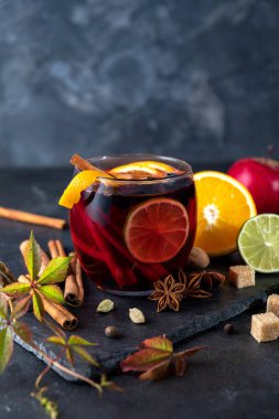 Baharatlı lezzetli kırmızı şarap. Sıcak şarap ve malzemeler karanlık masada.