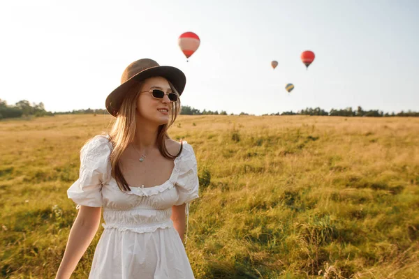 飛行気球を背景に野次馬の若い女性が歩き回り — ストック写真