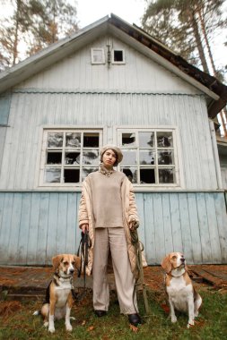 Ormanda iki av köpeği olan şık bir kadın.