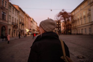 Akşamları genç bir kadın yürüyor. Yaşlı bir kadın.