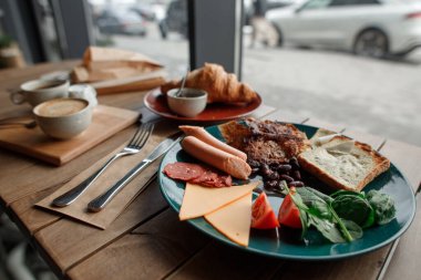 Lezzetli vejetaryen kahvaltısı çırpılmış tofu peyniri, soya fasulyesi sosisi ve fasulyesi.