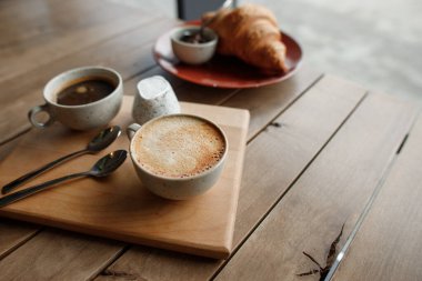 Kahvaltıda bir fincan güzel kokulu kahve ve çikolatalı kruvasan.