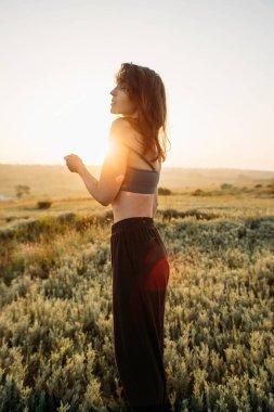 Gün batımında genç bir kadının atmosferik portresi