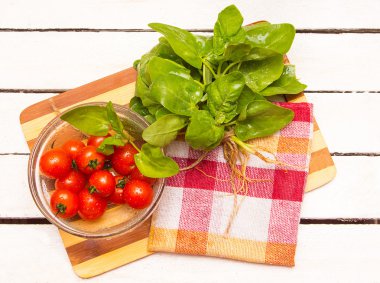 kiraz domates plaka ve bir paket taze ıspanak