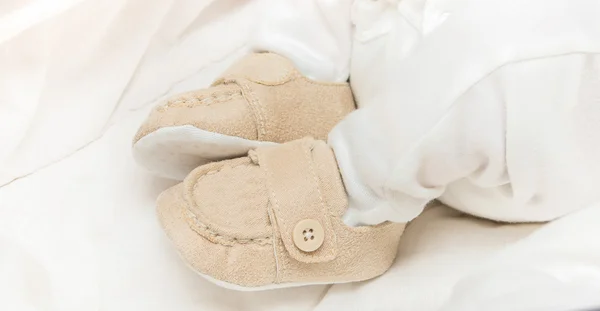 Botines de bebé en los pies del bebé — Foto de Stock