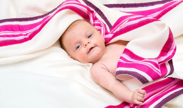 Neugeborenes Mädchen mit blauen Augen auf einer Decke liegend. — Stockfoto