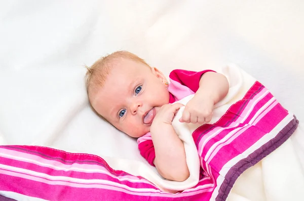 Pasgeboren meisje met blauwe ogen, liggend op een deken. — Stockfoto