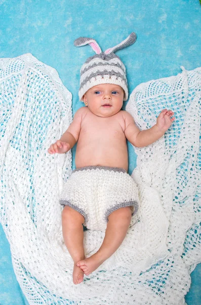 Pequeño bebé lindo en el conejito gorra sobre un fondo azul —  Fotos de Stock