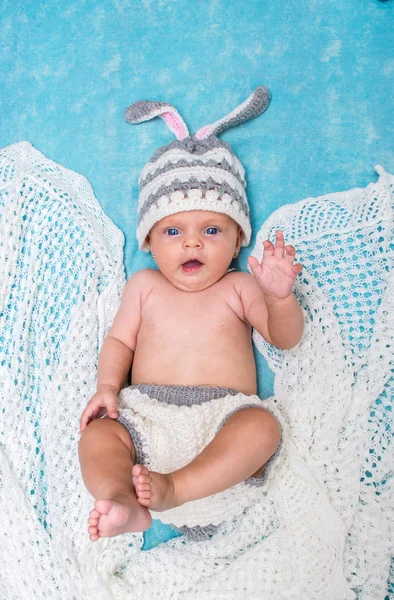 Pequeño bebé lindo en el conejito gorra sobre un fondo azul —  Fotos de Stock