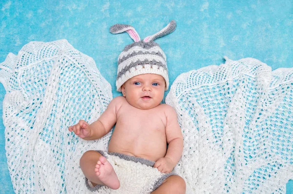 Pequeño bebé lindo en el conejito gorra sobre un fondo azul —  Fotos de Stock