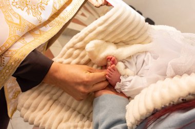 Yeni doğmuş bir bebeğin çıplak ayakları. Vaftiz töreni.