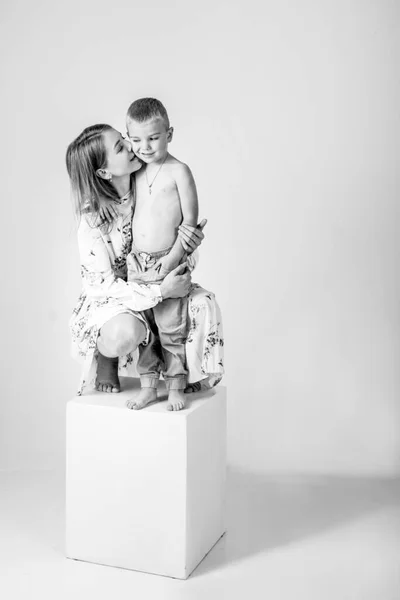 Mulher Bonita Beija Seu Filho Abraçando Fundo Cinza — Fotografia de Stock