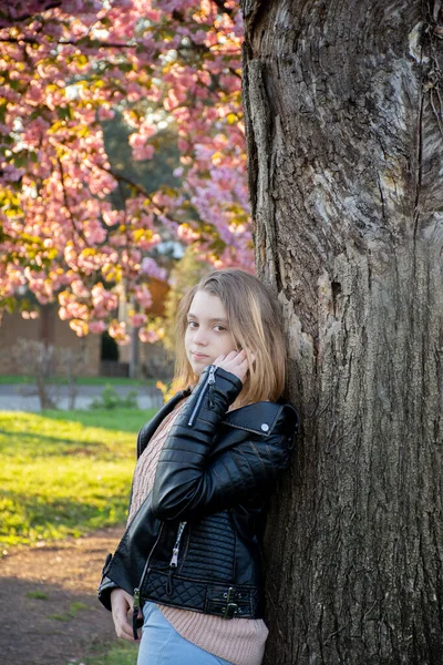 Portrét Mladé Dívky Kožené Bundě Pozadí Kvetoucích Sakura Stromů — Stock fotografie