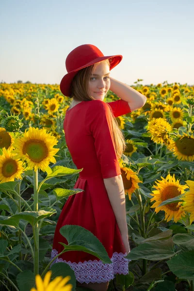 Portret Młodej Dziewczyny Czerwonej Sukience Kapeluszu Polu Słonecznikami Wschodzie Słońca — Zdjęcie stockowe