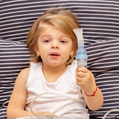 Astımı ya da alerjisi olan hasta bir sarışının ellerinde astım spreyi.