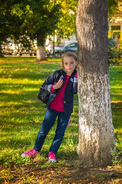 Pretty girl of school age in the autumn park. — Stock Photo, Image