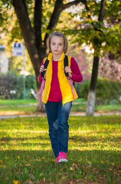 Pretty girl of school age in the autumn park. — Stock Photo, Image