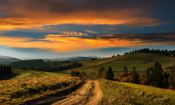 Широка дорога в Карпатах, на заході сонця. Ліцензійні Стокові Фото