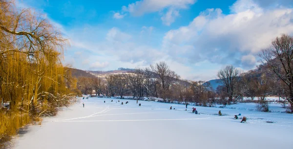 Pesca de hielo en un río congelado Fotos De Stock Sin Royalties Gratis