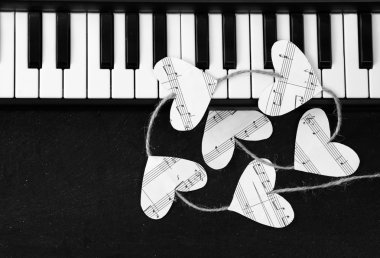 Piyano tuşları ve kalpleri siyah bir arka plan üzerinde müzik