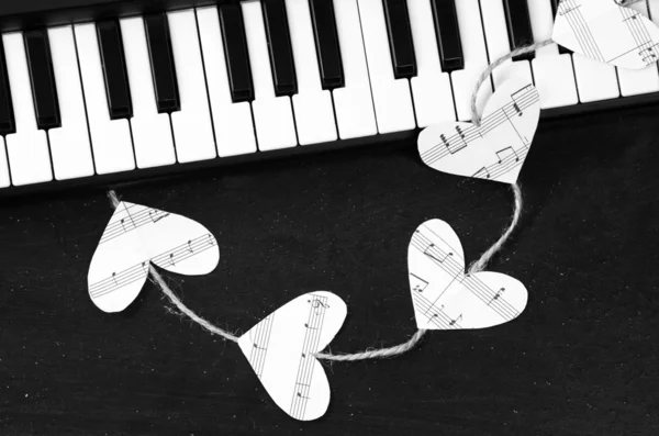 काळ्या पार्श्वभूमीवर पियानो की आणि संगीत हृदय — स्टॉक फोटो, इमेज