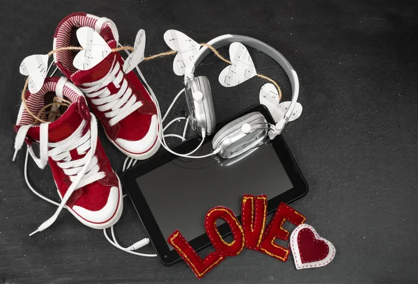 संगीताची संकल्पना आवडते. लाल स्निकर्स, हेडफोन्स, टॅबलेट आणि चांगले — स्टॉक फोटो, इमेज
