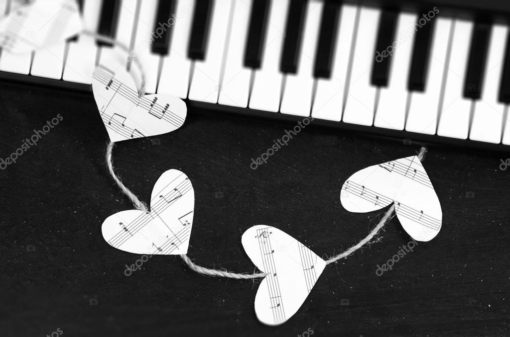 Piano keys and hearts of the music on a black background