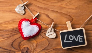 Boş plaka üzerinde clothespin yürekleri. Aşk sembolü.