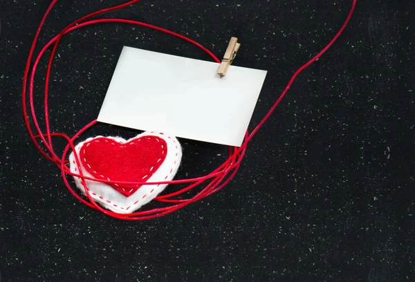 Herz aus Stoff auf schwarzem Hintergrund. Symbol der Liebe. — Stockfoto