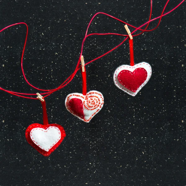 Três corações de tecido em um fundo preto. Símbolo do amor . — Fotografia de Stock