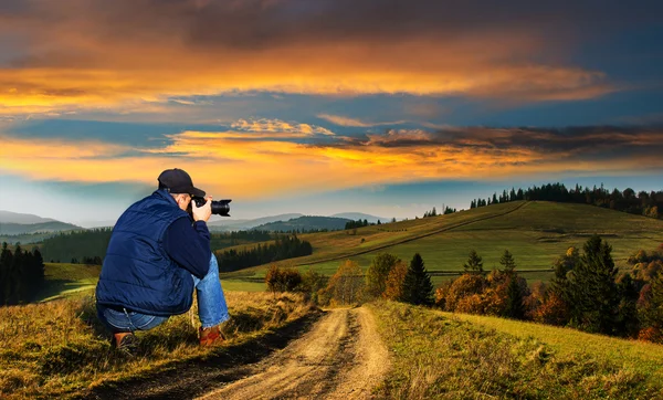 Hombre fotógrafo en las montañas al atardecer —  Fotos de Stock