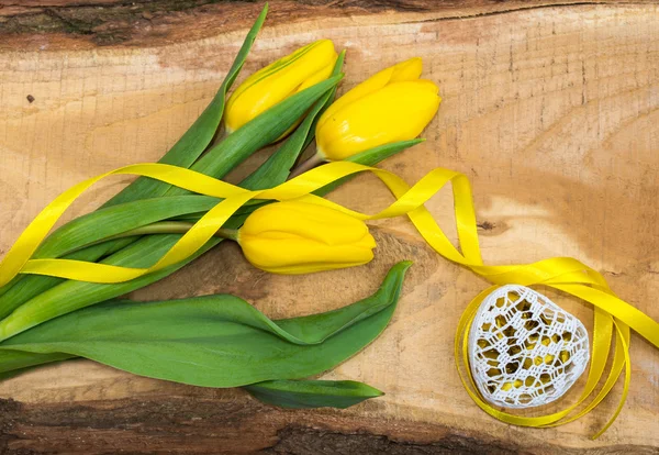 Fresh yellow tulips on a natural wooden board — Stock Photo, Image