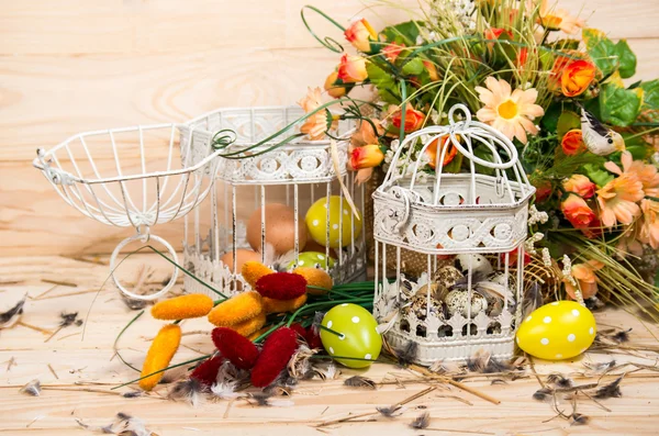 Easter still life. Bird cage with quail eggs and spring flowers — Stock Photo, Image