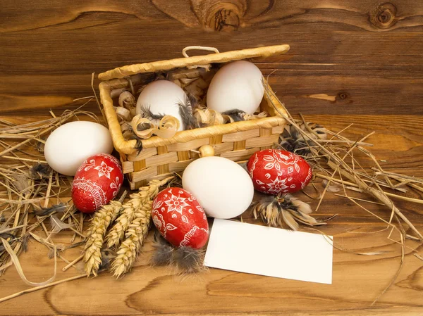 Ovos de frango de Páscoa em uma cesta em um fundo de madeira . — Fotografia de Stock