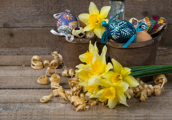 Пасхальные декоративные яйца в горшке и цветы нарцисса — стоковое фото
