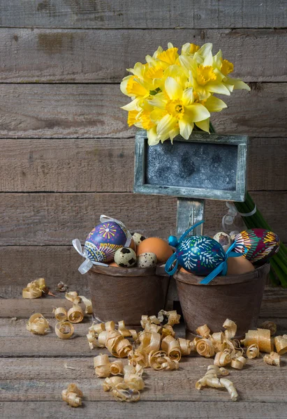 Easter decorative eggs in a pot and flowers of narcissus — Stock Photo, Image